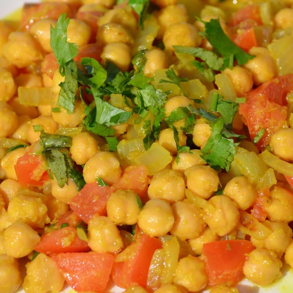 Close-up of Indian chana masala with chickpeas, tomatoes, onions, and cilantro.